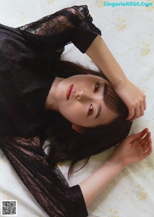 A woman in a red and white striped shirt posing for a magazine.