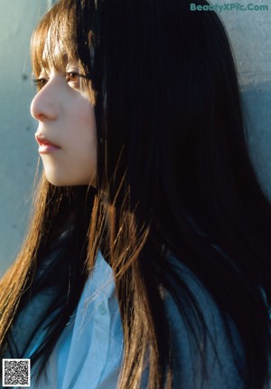 A woman looking out of a window at the sun.
