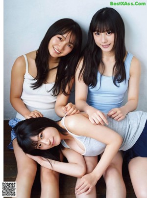 A couple of young women sitting on top of a couch.