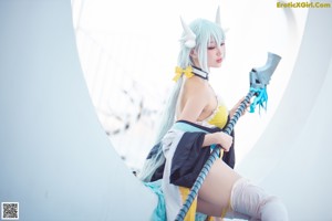 A woman in a yellow and white outfit holding a sword.