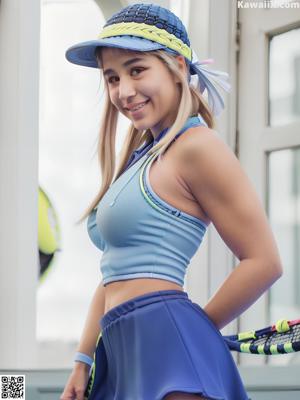 A woman in a purple sports bra top and purple panties posing in a gym.