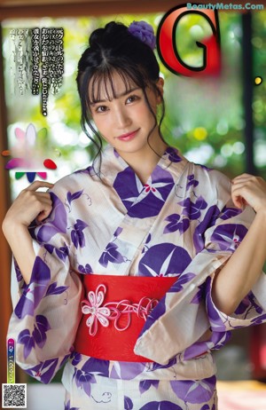 A naked asian woman in a kimono posing for the camera.