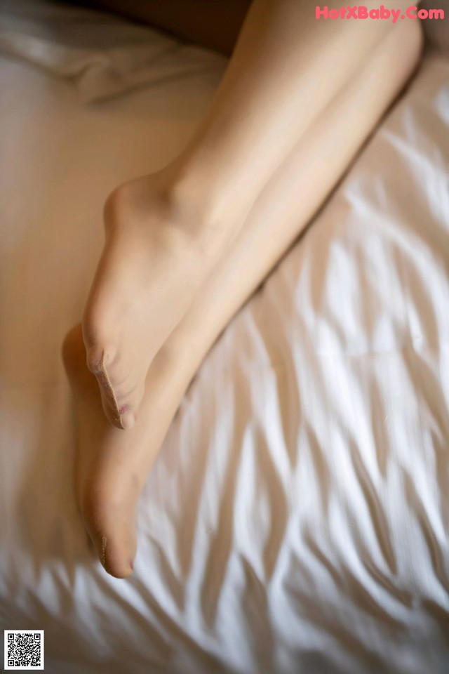 A close up of a woman's legs on a bed.