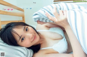A woman in a black lingerie laying on a bed.
