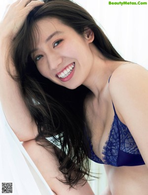 A woman laying on top of a bed in lingerie.