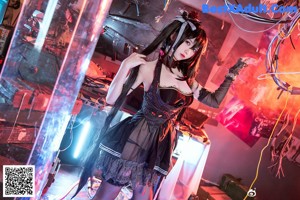 A woman in a black dress holding a bunch of wires.