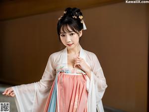 A woman in a white robe is posing for the camera.