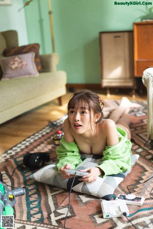 A woman sitting on a couch playing a video game.