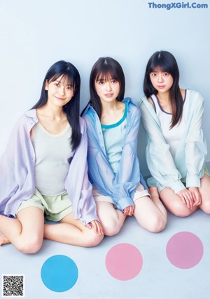 A group of young women sitting on top of a bed.