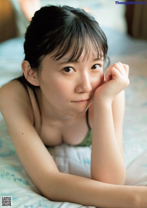 A woman in a white shirt and gray panties posing for a picture.
